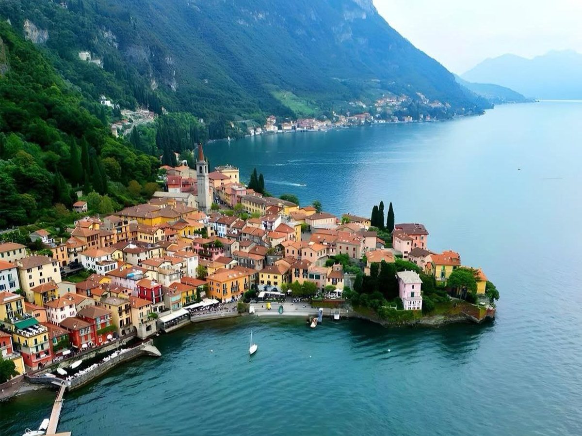 A lakeside town gathered around its church tower, houses stacked between the mountains and the water.